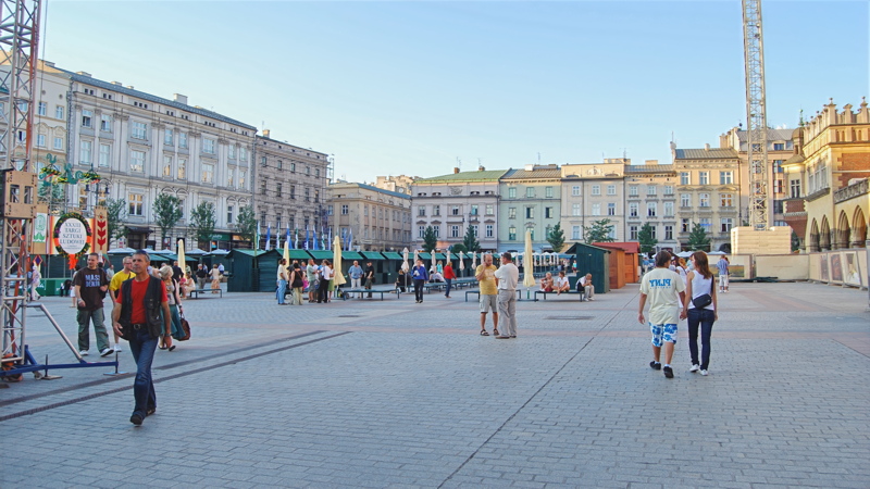 25 - The historic Main Market Square in Kraków, Poland, a vast medieval town square surrounded by old architecture, market stalls, and pedestrians